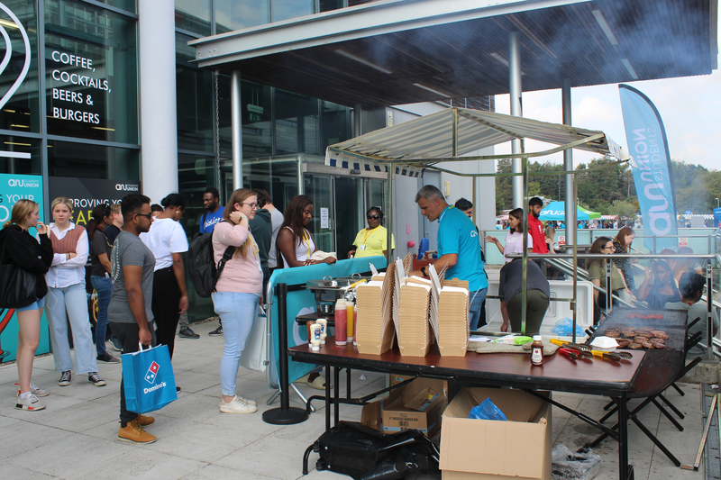 Students greeting each other at the Domino's stall