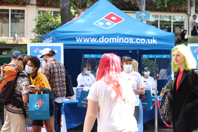 Students greeting each other at the Domino's stall